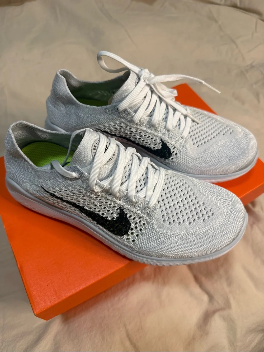 Nike White Flyknit Sneakers with Black Swoosh
